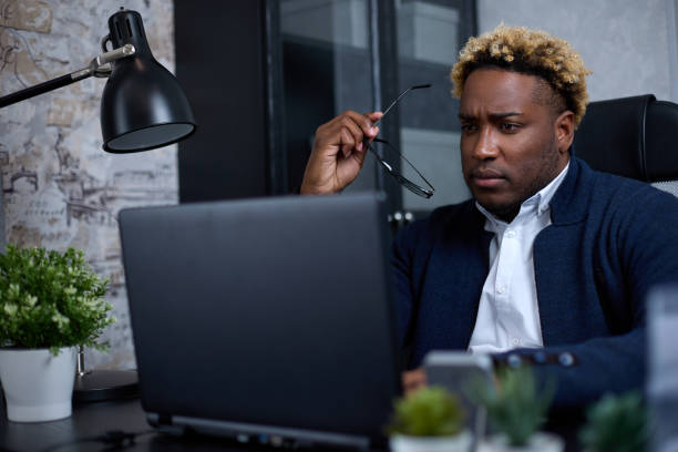istock Focused African businessman, thinking, looking at a laptop, doing research 1410285733