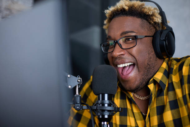istock Smiling black male gamer podcasting while playing on a computer at home 1410285738