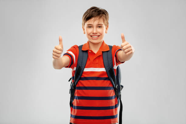 istock happy student boy with backpack showing thumbs up 1410286411