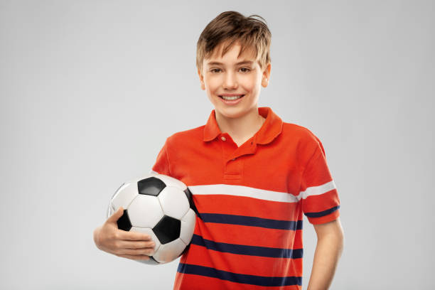 istock happy smiling boy holding soccer ball 1410286864
