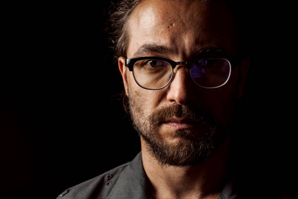 istock Dark studio portrait of a middle-aged man with beard in glasses 1410287557