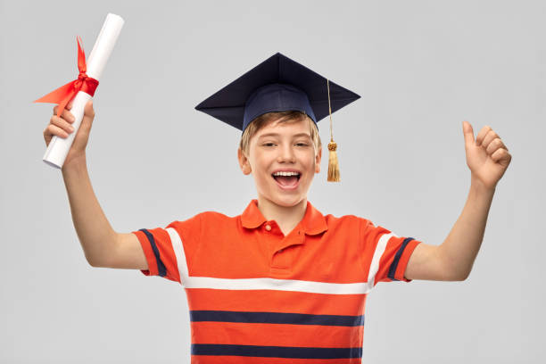 istock graduate student boy in mortarboard with diploma 1410287771