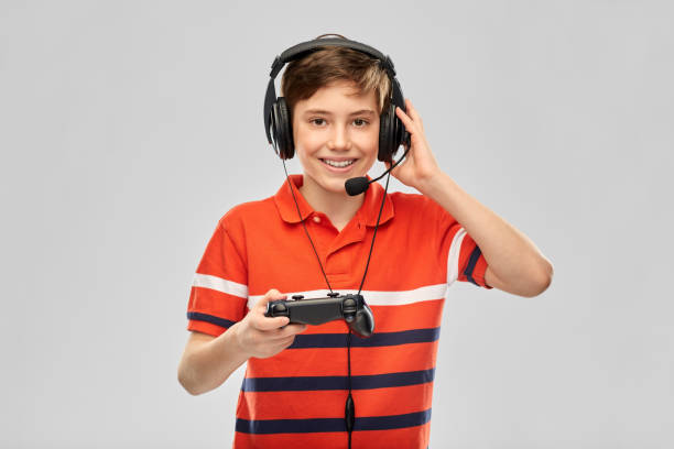 boy in headphones with gamepad playing video game stock photo