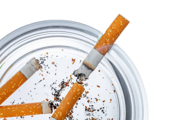 istock Burnt cigarette butts in an ash tray isolated on white 1410289093
