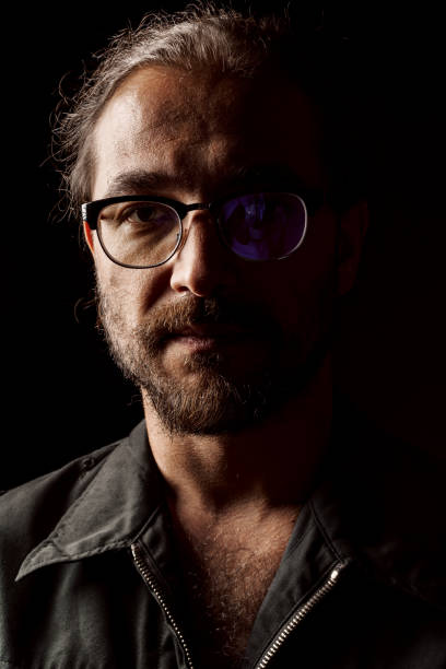 istock Dark studio portrait of a middle-aged man with beard in glasses 1410289152