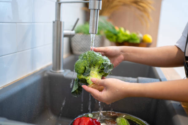 istock People washing vegetables in the kitchen. 1410289372