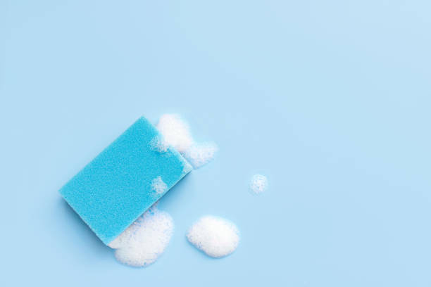 istock Multicolored sponges for cleaning on a blue background. Space for text. 1410289576