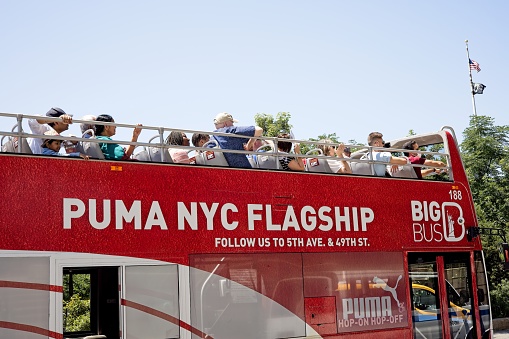 New York, NY, USA - July 22, 2022: A Big Bus tour bus showing people on the top deck of a double decker tour bus in Manhattan