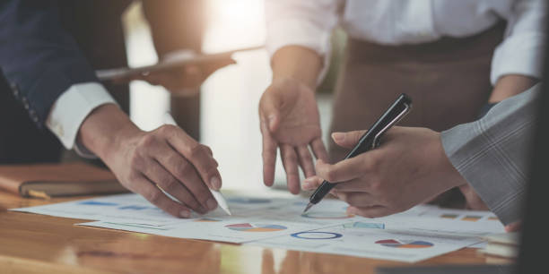 istock Photo team work process,holding contract hand,signs documents. Account managers young crew works with startup project.New idea presentation, analyze marketing reports. Blurred, film effect, horizontal 1410292552