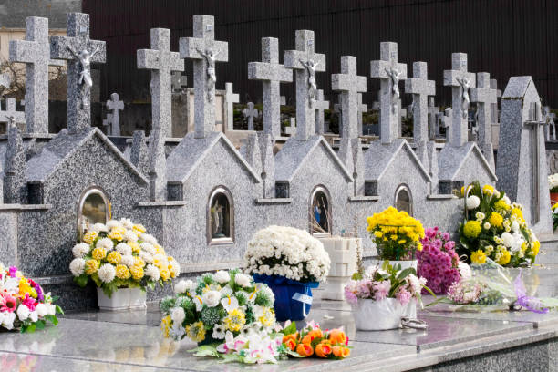 istock Rows of stone crosses and flowers in a graveyard. 1410292699
