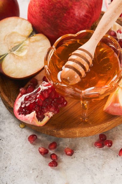 istock Rosh Hashanah. Pomegranate, apples and honey traditional products for celebration on rustic grey background. Jewish Autumn Rosh Hashana celebration. Jewish holiday Rosh Hashana design. Selective focus 1410292911