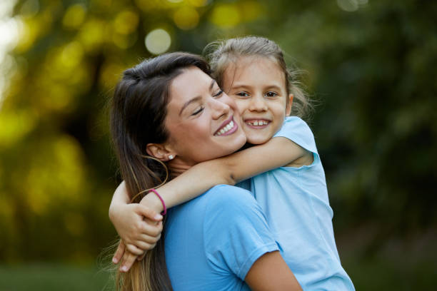 istock Mother and daughter sharing love while hugging in the park 1410293805