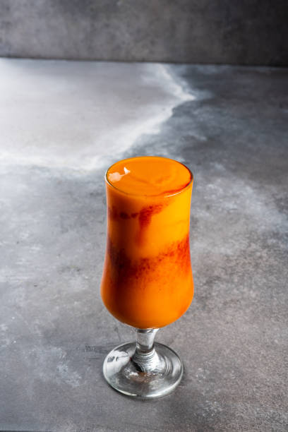 istock Fresh cocktail juice served in glass isolated on dark background side view 1410294146