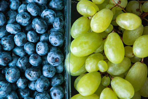 Fresh blueberries and grape, macro top view. Juicy fruits.