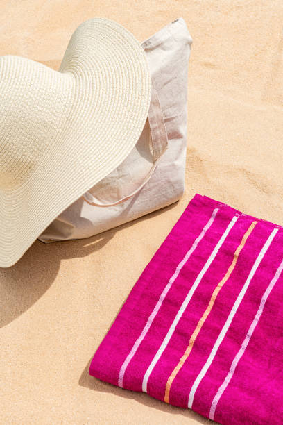 istock A straw hat on a canvas bag with towel on the beach sand 1410296895
