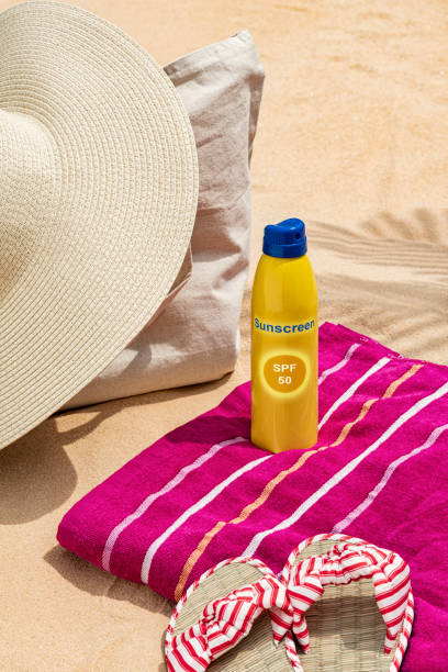 istock A straw hat on a canvas bag with sunscreen on towel sitting on the beach sand 1410296909