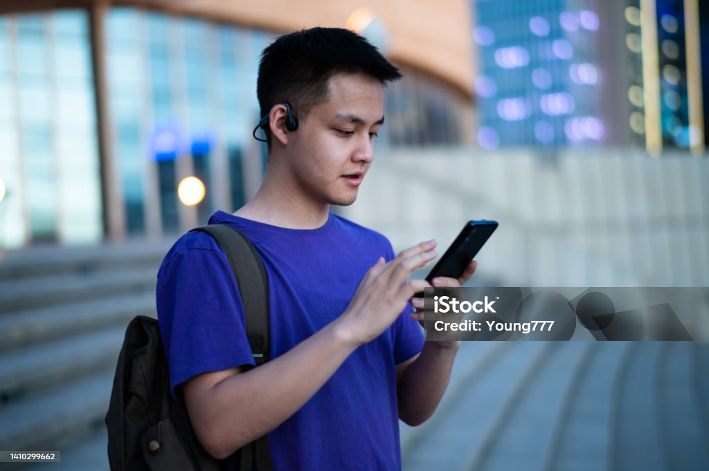 Asian adult student using smartphone at university campus Museum Stock Photo