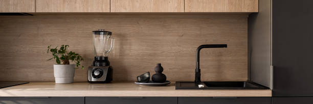 istock Wooden kitchen countertop with black sink, panorama 1410299980