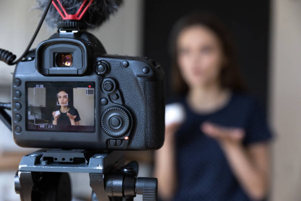 Young beauty blogger girl recording video on dslr camera stock photo