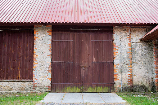 The door to an old brick barn covered with a corrugated metal roof