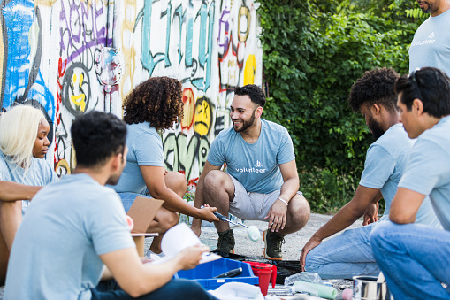 The group of volunteers take a break from painting the graffiti wall.