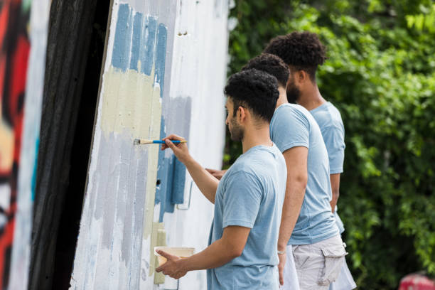 istock Young adults stand near each other as they paint 1410303208