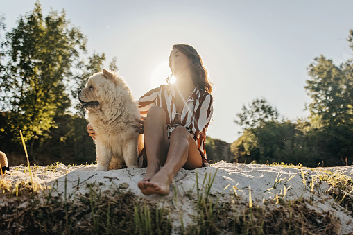 Beautiful young woman sitting with her chow chow dog and contemplating