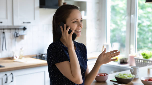 istock Happy joyful chef girl making telephone call in kitchen 1410304954