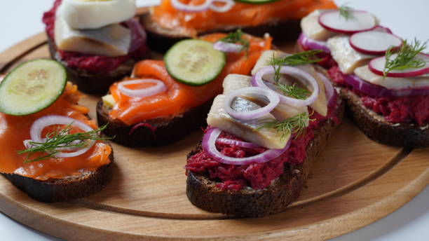 istock Danish open sandwich Smorrebrod on dark rye bread with herring, salmon, beetroot, red onions, and radish 1410304968