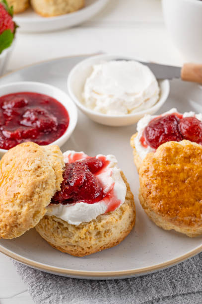 homemade british scones with cream cheese, strawberry jam and a cup of tea on a white wooden background. - brownie tea afternoon tea scone imagens e fotografias de stock