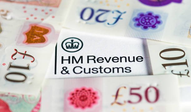 UK banknotes surrounding HM Revenue & Customs heading A collection of modern British banknotes surrounding the HMRC heading on a UK Government tax form. hm government stock pictures, royalty-free photos & images