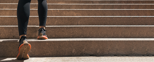 legs of girl doing sport while climbing stairs. image with copy space. concept of cardiovascular exercise and healthy life.