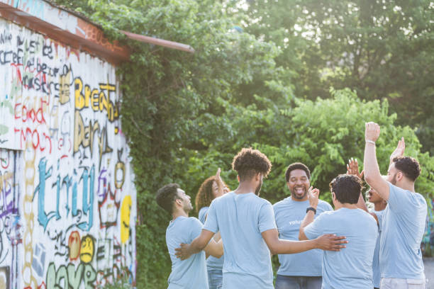 istock Before beginning graffiti clean-up, diverse volunteers huddle and cheer 1410319917