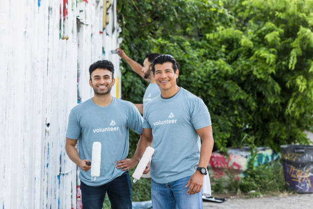 istock Adult brothers holding paint rollers smile for camera 1410319949