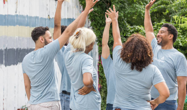 istock Volunteers throw up hands in show of unity 1410319982