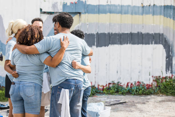 istock Volunteer team stands in huddle after graffiti clean up day 1410319985