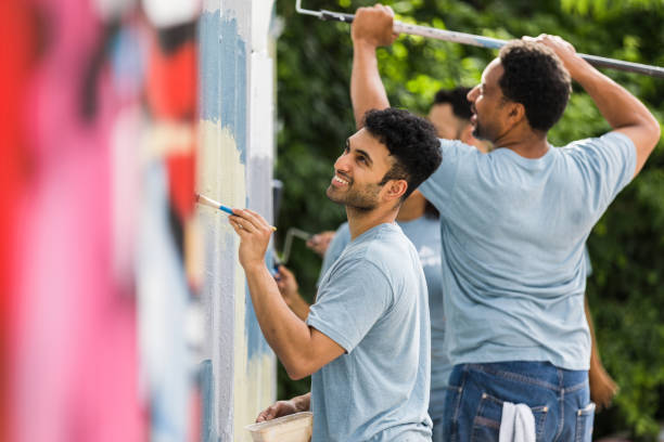istock Cheerful men volunteer time to paint over graffiti at park 1410319987