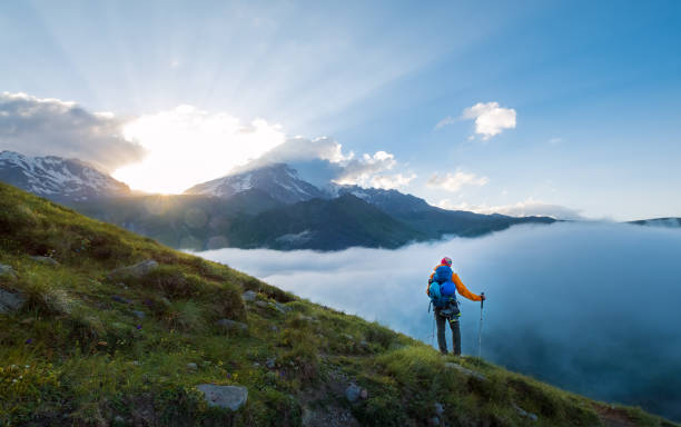 istock Lonely mountaineer descending from Kazbek 5054m mountain with backpack, helmets high mountaineering boots and trekking poles standing and enjoying sunset after successful ascending, Caucasus, Georgia. 1410321529