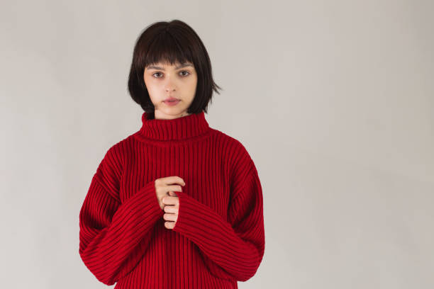 istock Brunette Asian girl in red pullover on white background. Beautiful model posing in studio. Bob hairstyle. Fashion style. Lipstick on lips. Adult woman. Smile on face 1410321976