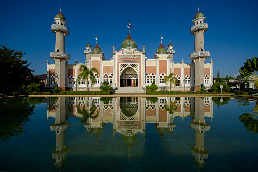 Beautiful central mosque and reflection in water at Pattani Central Mosque Thailand.(Translate Thai and Arab text in the picture is the name of The central mosque of Pattani Province)