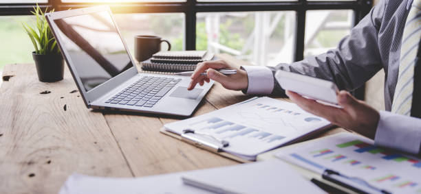 portrait d’un homme d’affaires travaillant sur une tablette dans un bureau moderne. faites un rapport d’analyse de compte. informations sur les placements immobiliers concepts du système financier et fiscal - formulaire des impôts photos et images de collection