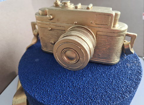 Blue delicious cake with golden chocolate camera. Photographer Cake