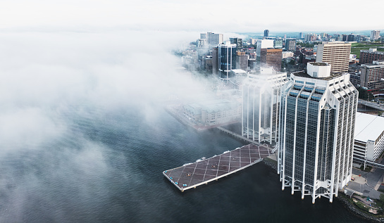 Aerial drone view of downtown Halifax & waterfront shrouded in fog.