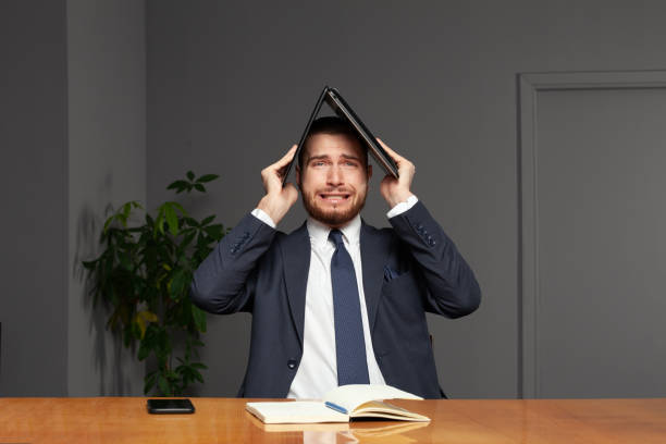 istock Stressed young businessman with laptop indoor in office 1410330477