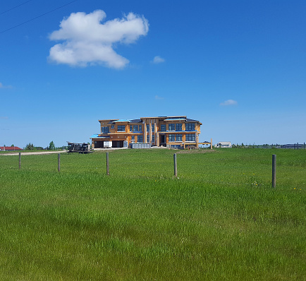 Calgary, Alberta, Canada- June 25,2022:  Exterior view of a very large expensive home being built on a rural Acreage.