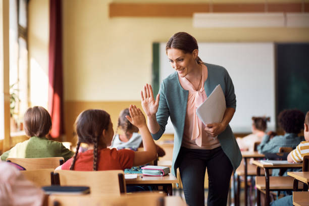 행복한 선생님과 여학생이 학교에서 수업 중에 하이 파이브를줍니다. - education 뉴스 사진 이미지