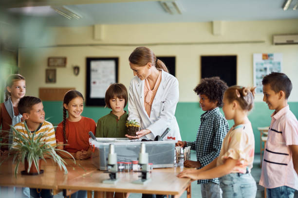 istock Happy teacher and school kids having botany class at school. 1410337547