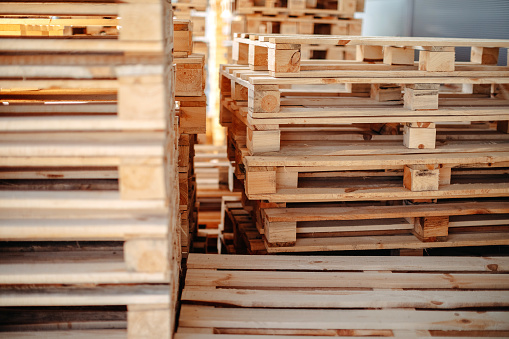 Empty wooden pallets packed in warehouse