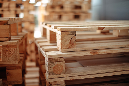 Empty wooden pallets packed in warehouse