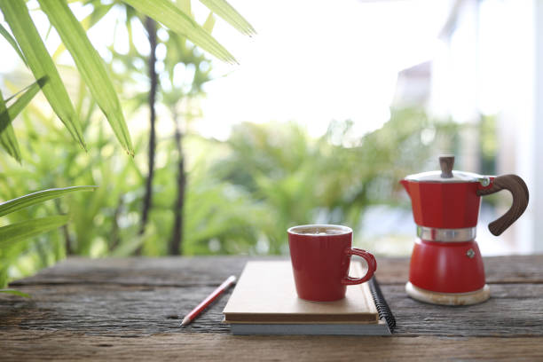 赤いコーヒーカップと赤いモカポットとノート - hot drink tea black tea red ストックフォトと画像